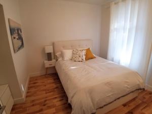 a bedroom with a white bed with a window at 3 bedroom near Olympic Stadium in Montréal