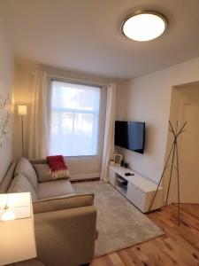 a living room with a couch and a television at 3 bedroom near Olympic Stadium in Montréal