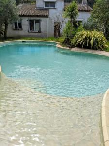 uma grande piscina de água em frente a uma casa em Retraite Tropicale à Marseille em Marselha