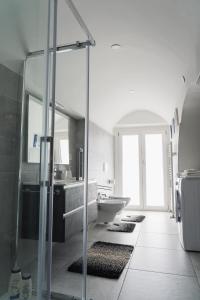 een badkamer met een glazen douche met tapijten op de vloer bij La Corte di Navarrete in Laterza