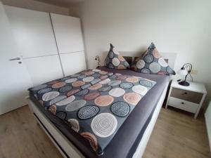 een slaapkamer met een groot bed met kussens bij BodenSEE Apartment Wasserburg "Im tiefen Brunnen" in Wasserburg
