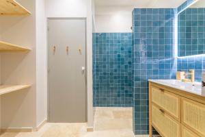 La salle de bains est pourvue d'une douche avec du carrelage bleu. dans l'établissement Magnifique appartement centre historique, à Aix-en-Provence