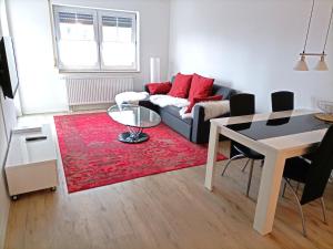 een woonkamer met een bank en een rood tapijt bij BodenSEE Apartment Wasserburg "Im tiefen Brunnen" in Wasserburg