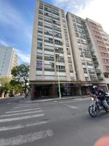 un homme qui fait une moto devant un bâtiment dans l'établissement Departamento centrico excelente ubicacion Bahia Blanca, à Bahía Blanca