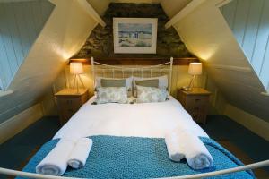 a bedroom with a bed with towels on it at Cable Cottage in Llanrhyddlad