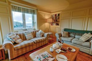 a living room with two couches and a table at Cable Cottage in Llanrhyddlad
