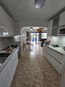 a kitchen and living room with a table in it at JUMA HOLIDAYS in Puerto del Carmen