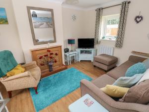 a living room with a couch and a tv at 4 Honeyborough Farm Cottages in Milford Haven