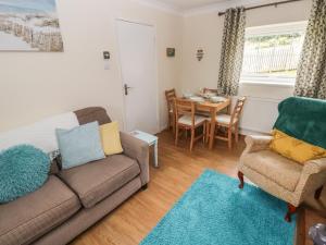 a living room with a couch and a table at 4 Honeyborough Farm Cottages in Milford Haven