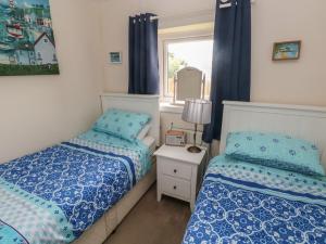 um quarto com 2 camas e uma janela em 4 Honeyborough Farm Cottages em Milford Haven