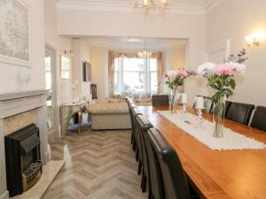 a living room with a long table with flowers on it at The Keep in Llandudno