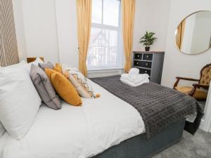 a bedroom with a white bed with pillows and a window at The Keep in Llandudno +46 photos