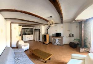 un soggiorno con un divano e un tavolo di Maison de ville au cœur d'un village de caractère dans le jura a Saint-Julien