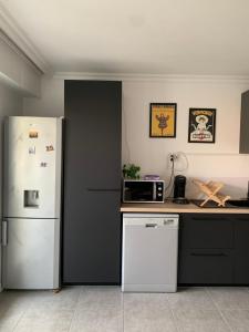 La cuisine est équipée d'un réfrigérateur blanc et d'un four micro-ondes. dans l'établissement Lokitas, à Marseille
