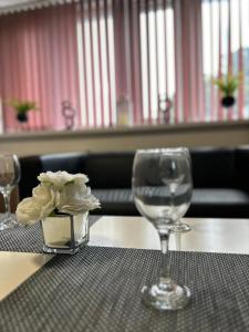 a table with a wine glass and a flower on it at Bv Cozy Deighton Studio with Free Parking - Budget-Friendly Stay in Huddersfield