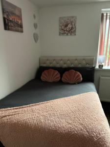 1 dormitorio con 1 cama con 2 almohadas en Bv Cozy Deighton Studio with Free Parking - Budget-Friendly Stay, en Huddersfield