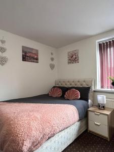 um quarto com uma cama grande e um cobertor rosa em Bv Cozy Deighton Studio with Free Parking - Budget-Friendly Stay em Huddersfield