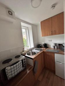 a small kitchen with a sink and a window at Bv Cozy Deighton Studio with Free Parking - Budget-Friendly Stay in Huddersfield