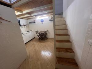 Zimmer mit einer Treppe und einer Küche mit einem Tisch in der Unterkunft Casa Basile 15 in Neapel