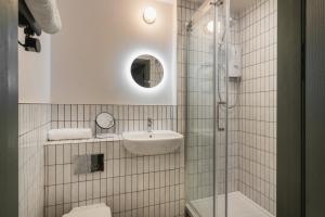 a bathroom with a toilet and a sink and a shower at The Cotham Arms Apartments in Bristol