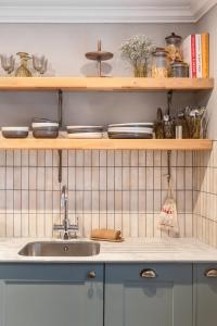 a kitchen with a sink and wooden shelves at The Cotham Arms Apartments in Bristol