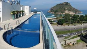 una piscina en la parte superior de un edificio junto al océano en Atlantico Sul Hotel en Río de Janeiro