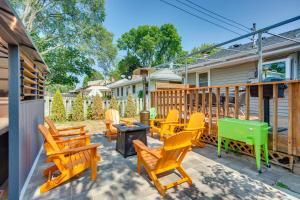 un patio con sillas de madera y una parrilla en Pet-Friendly Minneapolis Home about 8 Mi to Downtown!, en Minneapolis