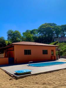 een klein huis met een zwembad ervoor bij Casa Califórnia in Lindóia