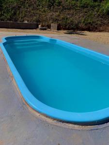 een groot blauw zwembad bovenop een weg bij Casa Califórnia in Lindóia