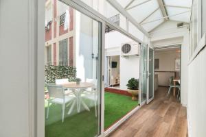 une extension en verre d'une maison avec une table et des chaises dans l'établissement Roisa Centro, à Madrid