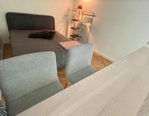 - une chambre avec un lit, deux chaises et un canapé dans l'établissement Cosy loft in Kaunas center, à Kaunas
