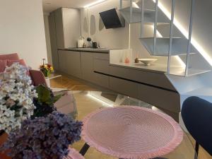 Il comprend un salon avec une table et une cuisine. dans l'établissement Cosy loft in Kaunas center, à Kaunas