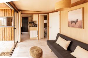 ein Wohnzimmer mit einer schwarzen Couch und einem Zebra in der Unterkunft Les Gîtes du Bioparc 
