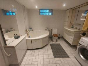 een badkamer met een bad, een toilet en een wastafel bij Remarkable 1-Bed Apartment in Orebro in Örebro
