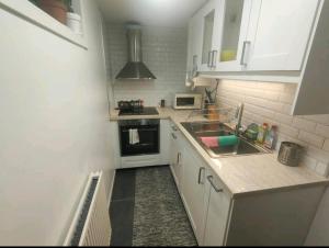厄勒布魯的住宿－Remarkable 1-Bed Apartment in Orebro，白色的厨房设有水槽和炉灶。