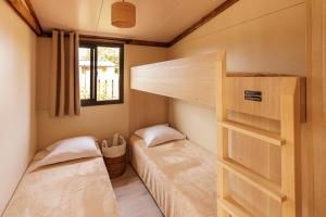 2 Etagenbetten in einem kleinen Zimmer mit Fenster in der Unterkunft Les Gîtes du Bioparc 