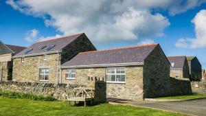a stone house with a bench in front of it at Efail Penrhyn in Llanfachraeth