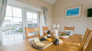 a dining room with a wooden table and a window at Efail Penrhyn in Llanfachraeth