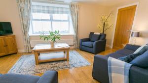 a living room with a couch and a coffee table at Efail Penrhyn in Llanfachraeth