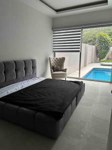 1 dormitorio con cama, silla y piscina en Casa privada en Villa Bricia, en Cuernavaca