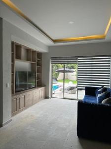 uma sala de estar com um sofá azul e uma televisão em Casa privada en Villa Bricia em Cuernavaca