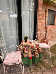 una mesa y dos sillas sentadas junto a una ventana en Las casitas del Gallego, en Villanueva de Gállego