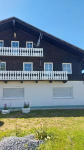 a large house with a white wall and windows at Ferienwohnung Eleni in Mauth