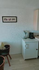 a kitchen with a small white refrigerator and a chair at Ferienwohnung Eleni in Mauth