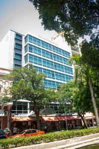 un edificio alto con un coche aparcado delante de él en HOTEL MANZUR en Barranquilla