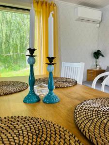 Kaffestugan في Hällefors: وجود مزهريتين زرقاوين فوق طاولة خشبية