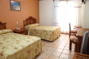 a hotel room with two beds and a window at Hotel Oaxaca Dorado in Oaxaca City +23 photos