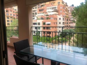 a balcony with a table and chairs and a building at Monaco F1 Port de Fontvieille refined apartment overlooking the garden, with pool access, 10 min from GP in Monte Carlo