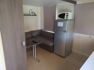 een kleine kamer met een koelkast en een magnetron bij Logement entier wifi stationnement gratuit in Voiron