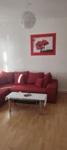 a living room with a red couch and a coffee table at FeWo Am Tummelplatz in Blankenburg
